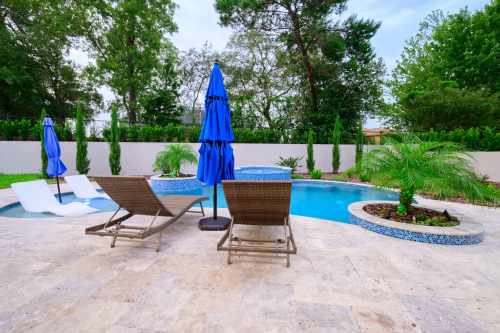 Backyard pool in Weeki Wachee with blue umbrellas and lounge chairs