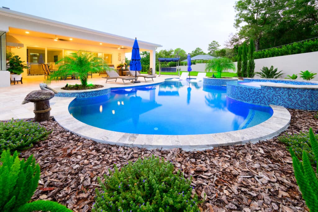 Beautiful Weeki Wachee backyard pool with a curved design, vibrant landscaping