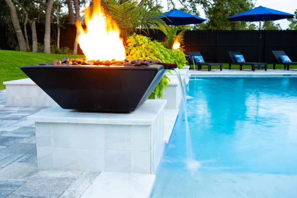 Black fire water bowl at the edge of the pool, enhancing the backyard's modern design