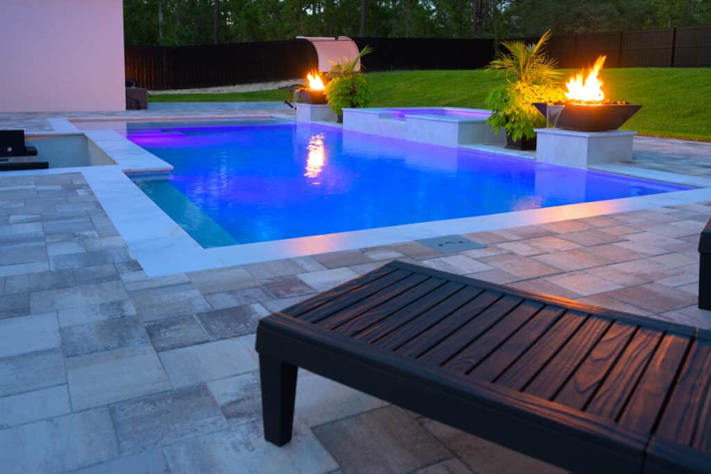 Black fire water bowl with dancing flames, enhancing the poolside ambiance