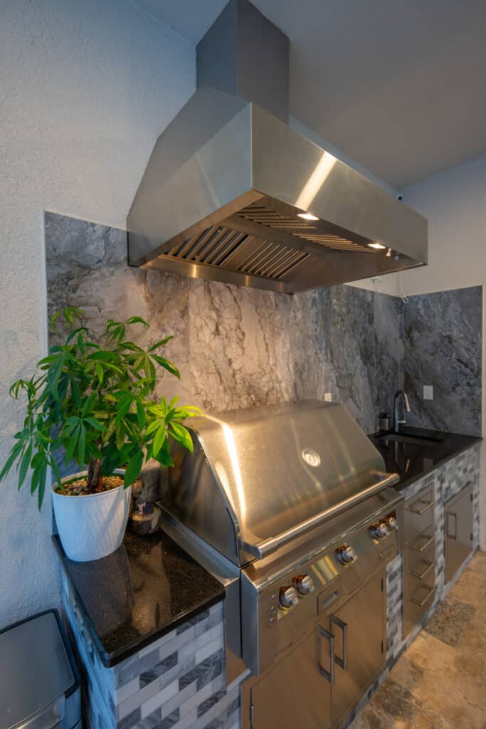 Close-up of a modern outdoor kitchen with stainless steel appliances and stone accents