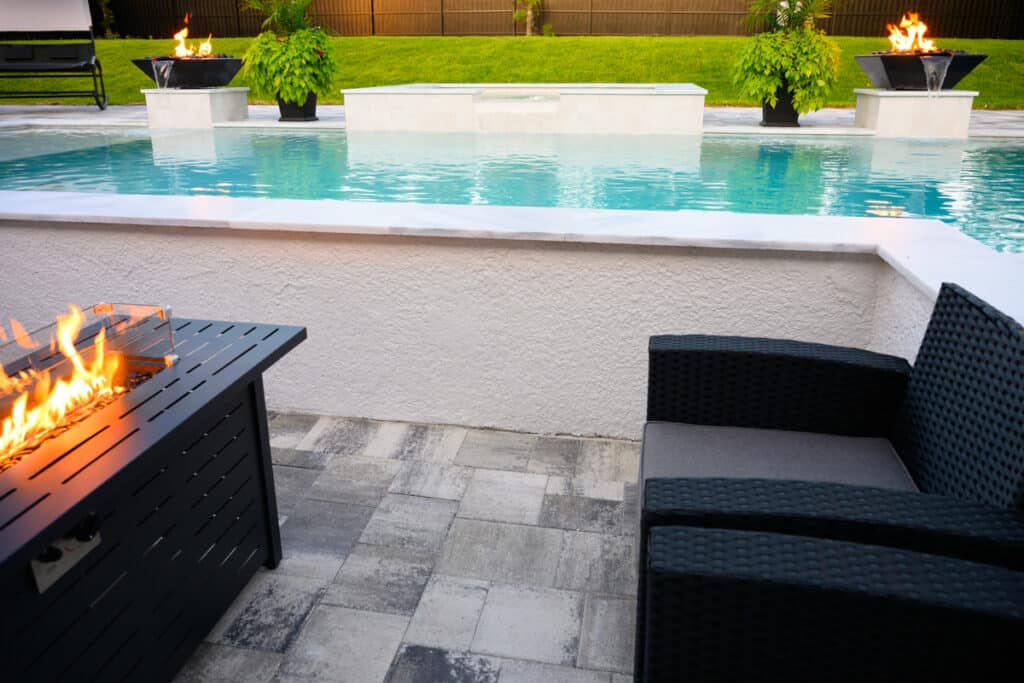 Comfortable seating area with a fire pit, providing a cozy spot for evening relaxation by the pool in Weeki Wachee, FL.