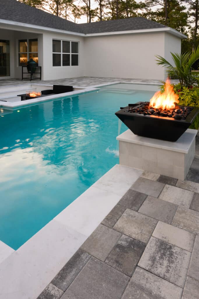 Elegant pool with a black fire water bowl, creating a stunning backyard focal point.