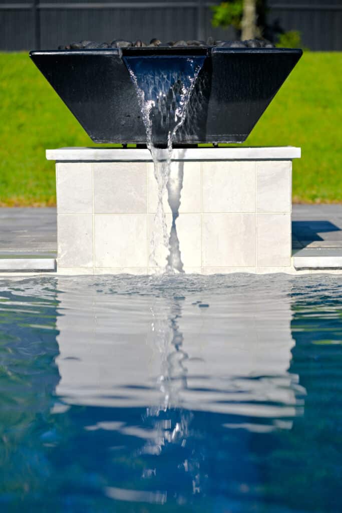 Elegant water feature flowing into the pool