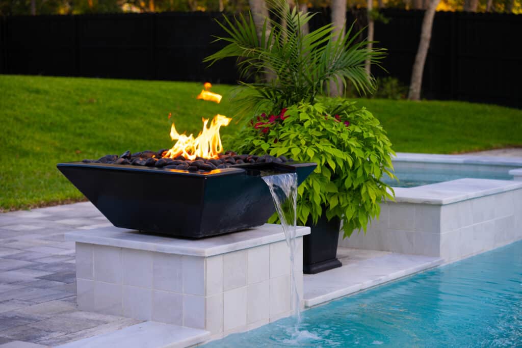 Fire water bowl at the edge of a modern pool, enhancing the outdoor space's luxurious feel