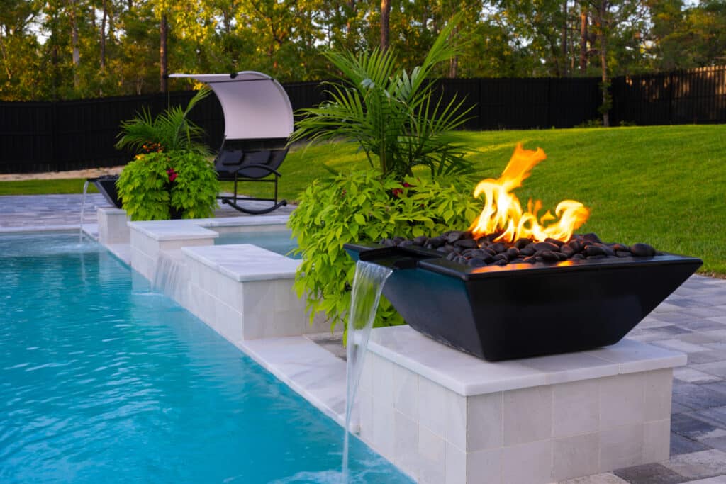 Fire water bowl next to the pool, illuminating the night with its warm glow in Weeki Wachee, FL.