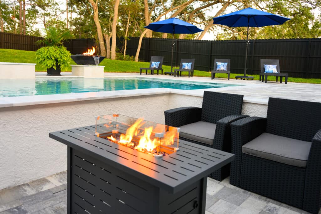 Vibrant pool with clear blue water, surrounded by a manicured lawn and comfortable seating.