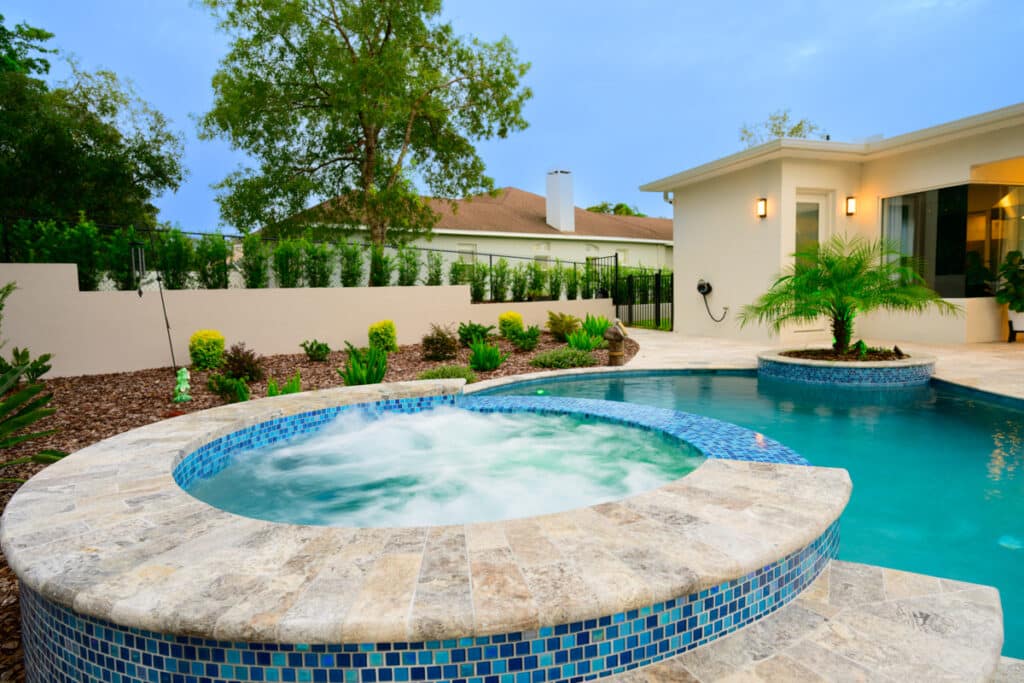 Weeki Wachee backyard featuring a luxurious pool with a circular hot tub and vibrant LED lights