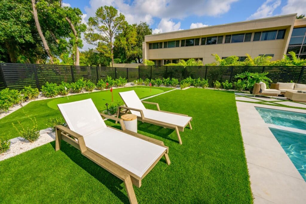 Comfortable sun loungers positioned on lush grass near the pool.