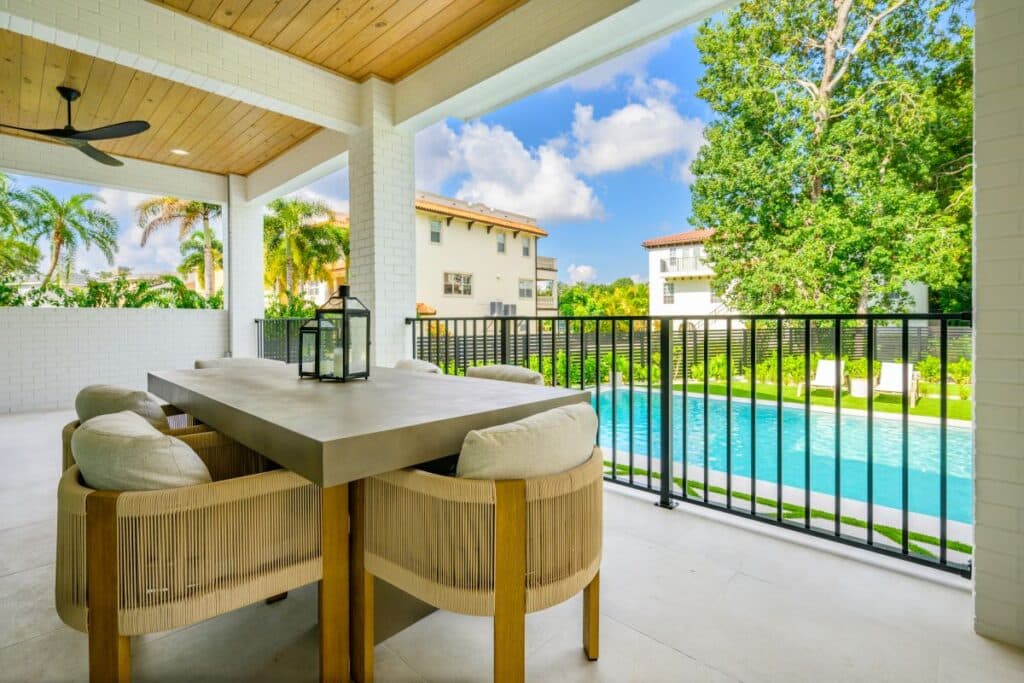 Covered patio with potted plants and a view of the geometric backyard pool.