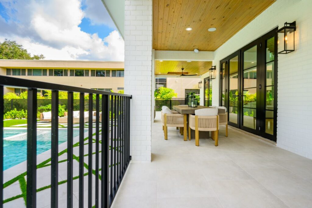 Modern outdoor patio with cushioned seating and views of the backyard.