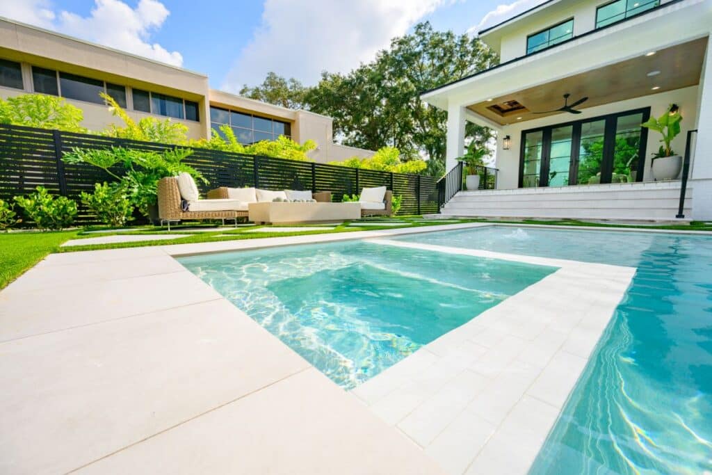 Modern pool with sleek, light stone pavers and a minimalist design.