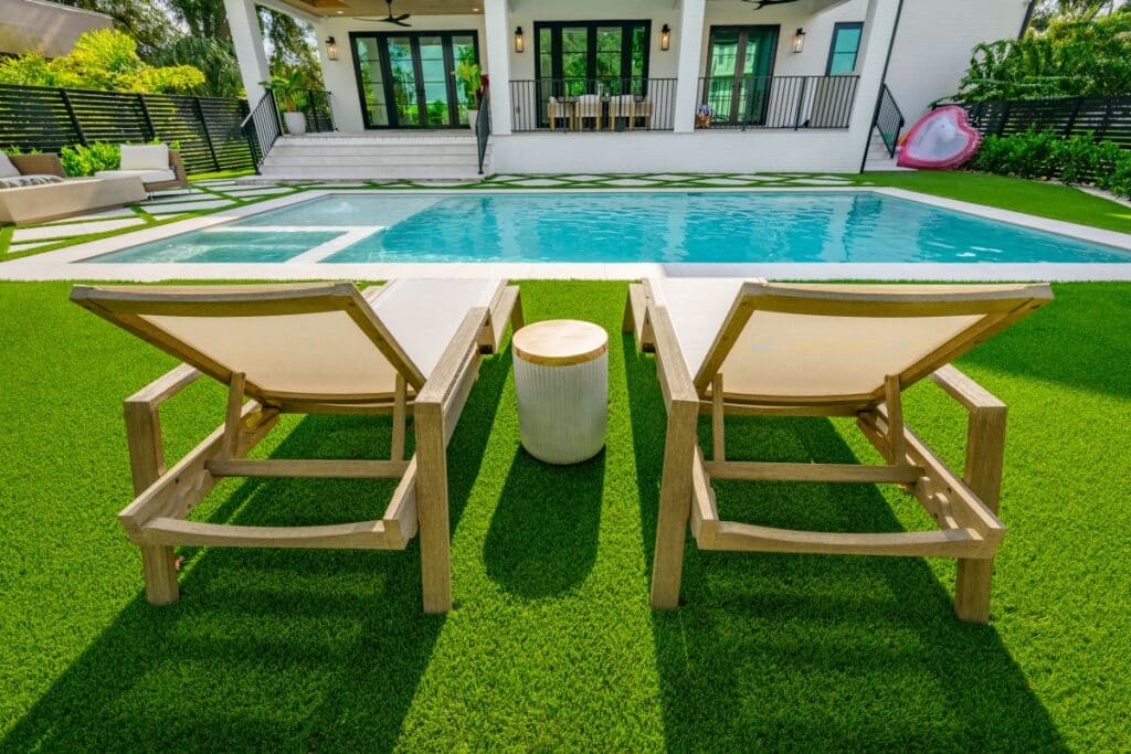 Poolside area with stylish loungers and manicured green lawn.