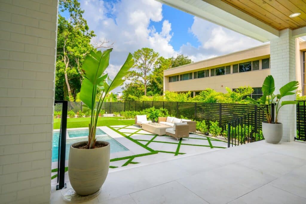 Shaded patio area with cushioned seating and views of the backyard.