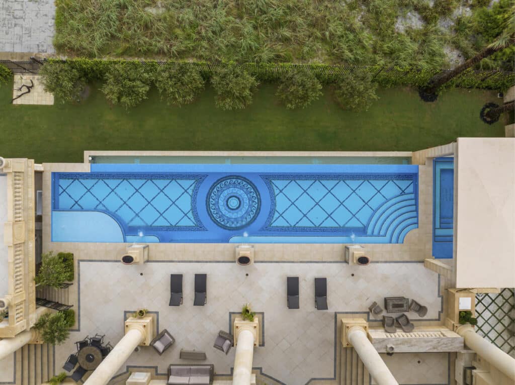 Aerial view of a custom pool in Tampa with intricate tile work and spacious lounge areas ideal for backyard relaxation