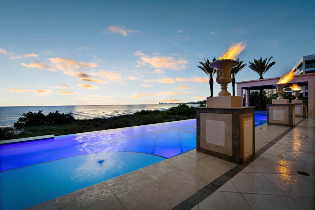 Custom Tampa pool featuring fire bowls and vibrant lighting, designed for a dramatic evening setting.