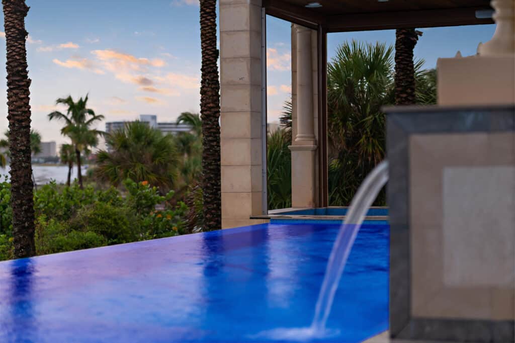 Infinity-edge pool in Tampa with a classical architectural backdrop, merging timeless design with modern luxury.