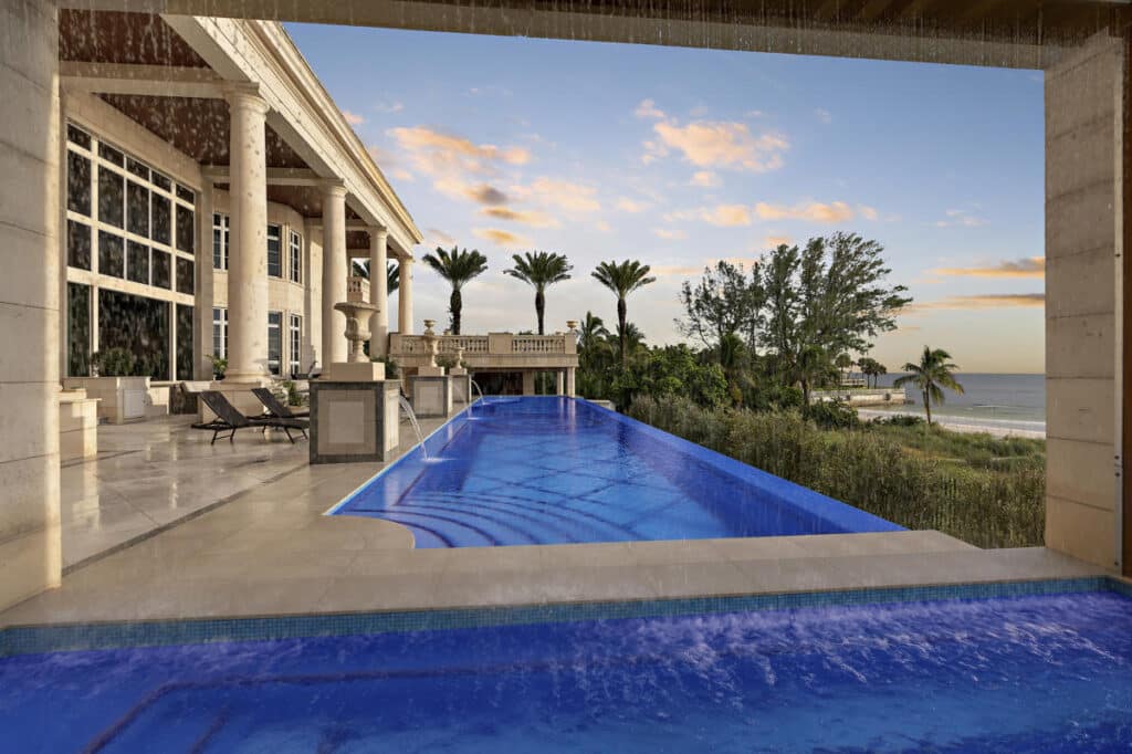 Luxury pool in Tampa with a sheltered lounge area and lush landscaping, offering a private and relaxing outdoor escape.