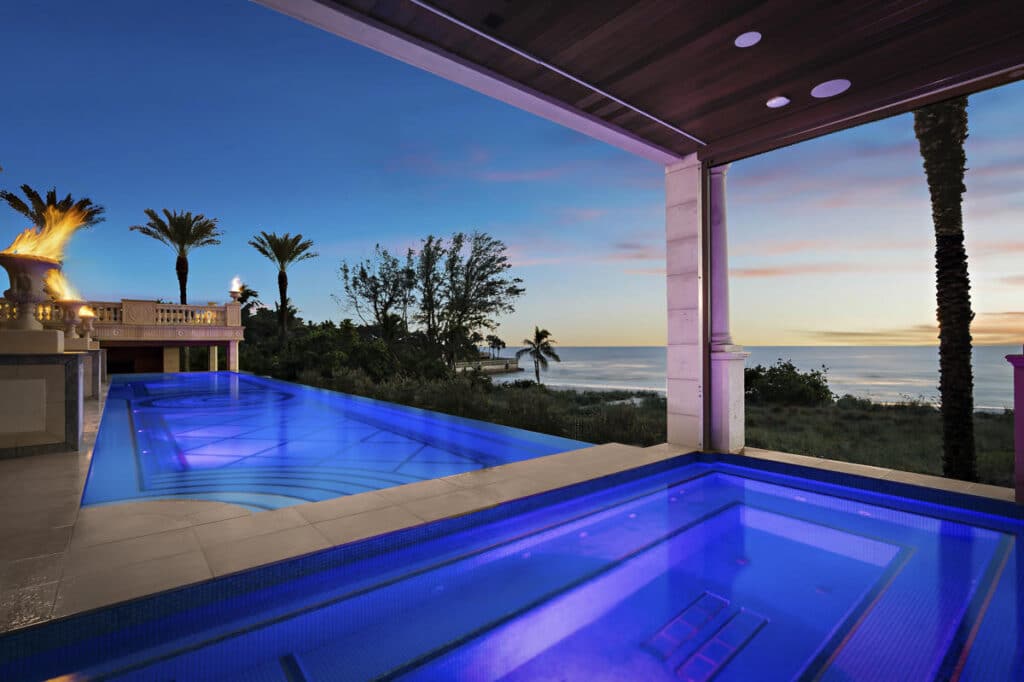 Luxury pool in Tampa with integrated lighting and a sheltered lounge area, creating an inviting nighttime ambiance.