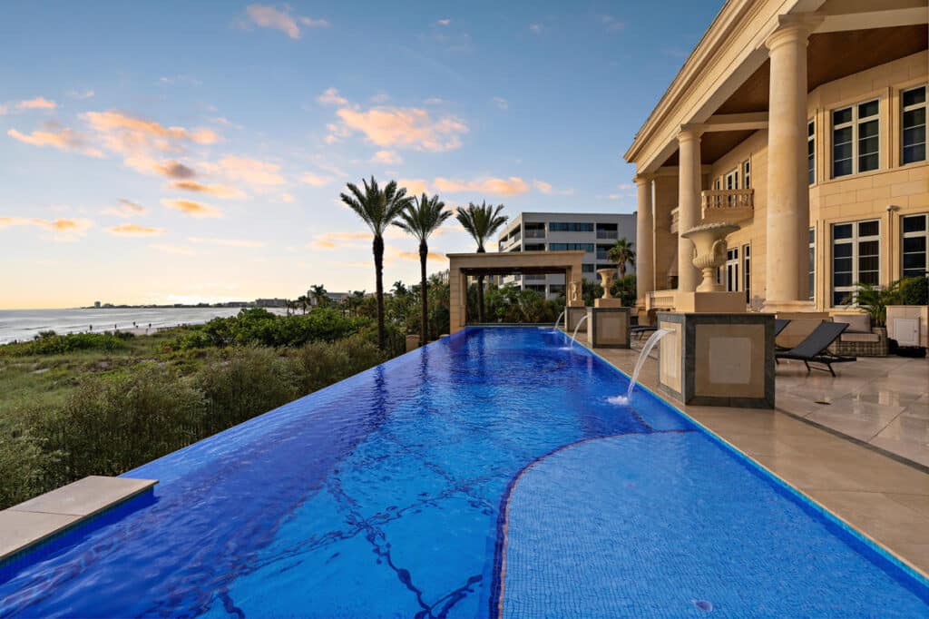 Modern Tampa pool with an infinity edge and spacious sundeck, perfect for luxurious backyard relaxation and entertaining.