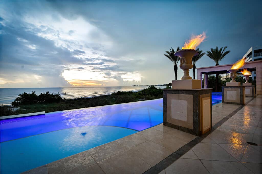 Modern infinity-edge pool in Tampa, surrounded by palm trees and a sleek patio, offering a luxurious retreat.