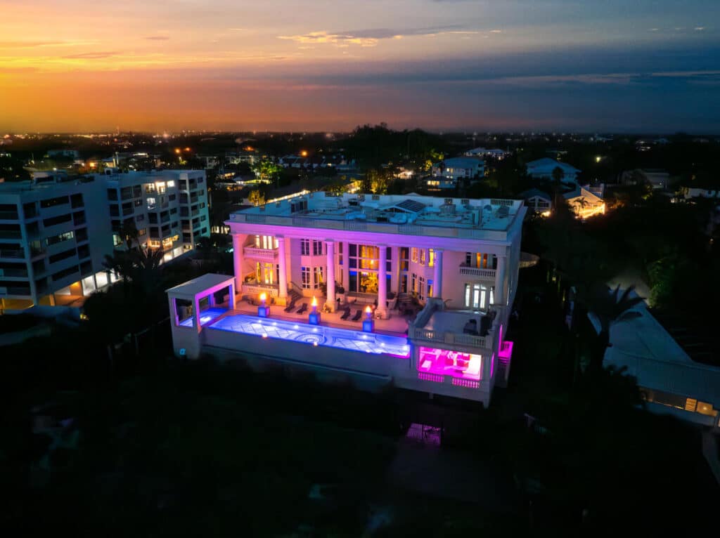 Night aerial shot of a luxury pool in Tampa with dynamic lighting highlighting a modern outdoor space