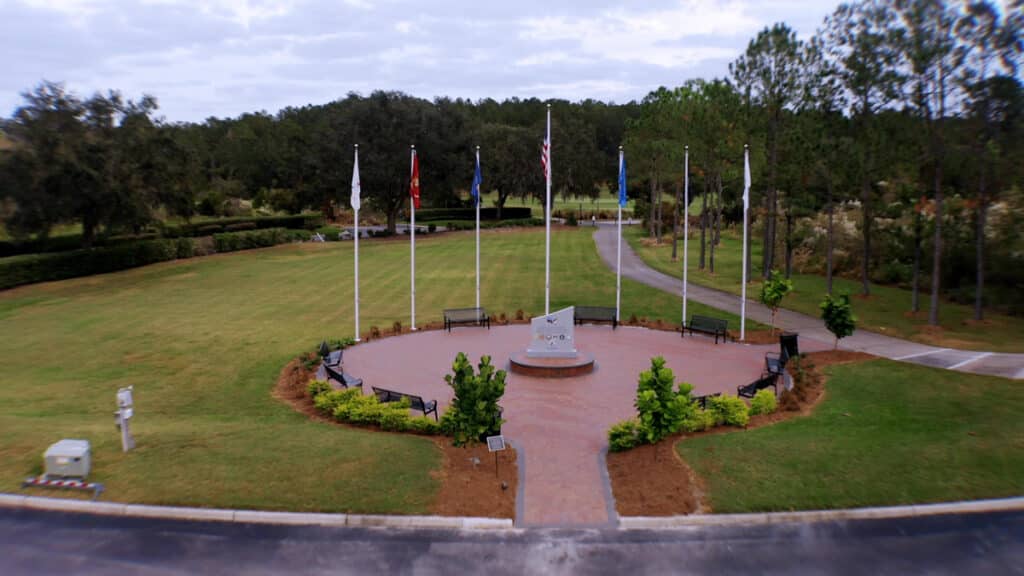 Aerial view of the Southern Hills Veterans Memorial, showcasing the monument, flagpoles, and paver pathways.