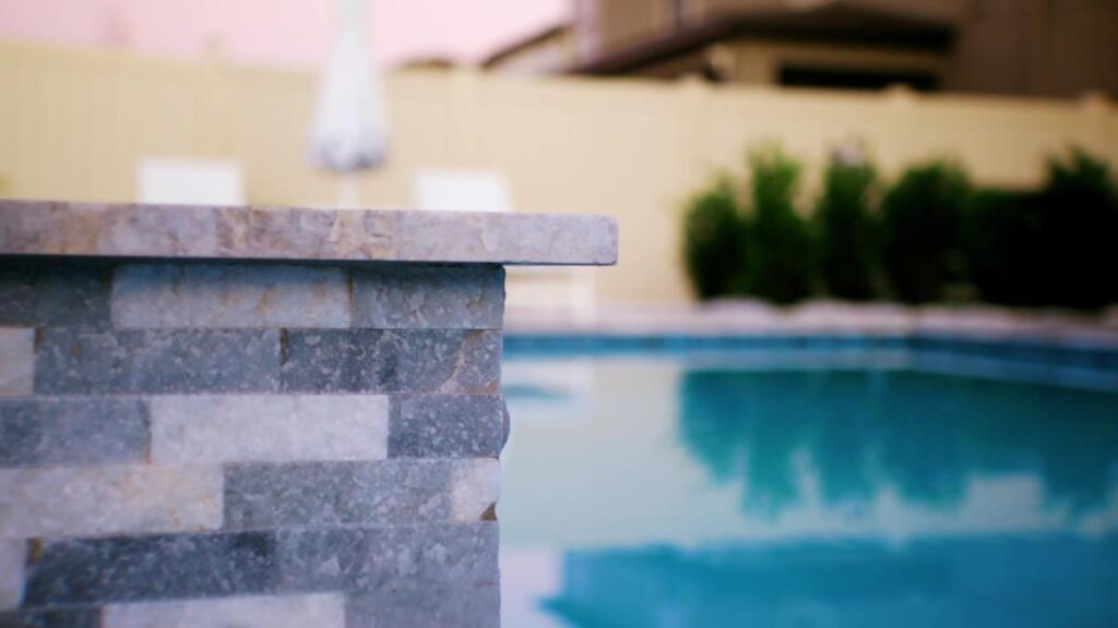 Close-up of luxury pool deck tiles next to a custom pool.