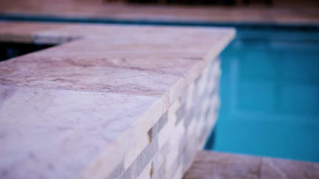 Travertine pool decking beside an inground pool.